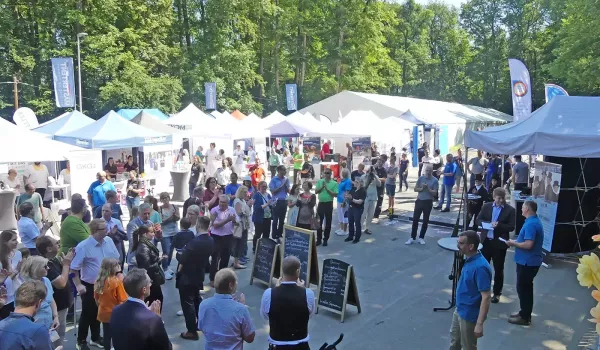 Foto der Messe, außen mit Zelten und vielen Besuchern