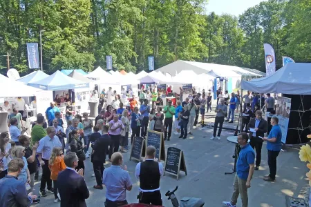 Foto der Messe, außen mit Zelten und vielen Besuchern